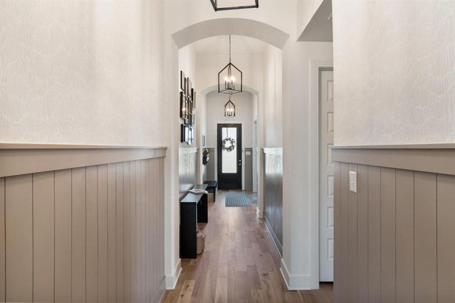 Hallway with a notable chandelier and light wood-type flooring