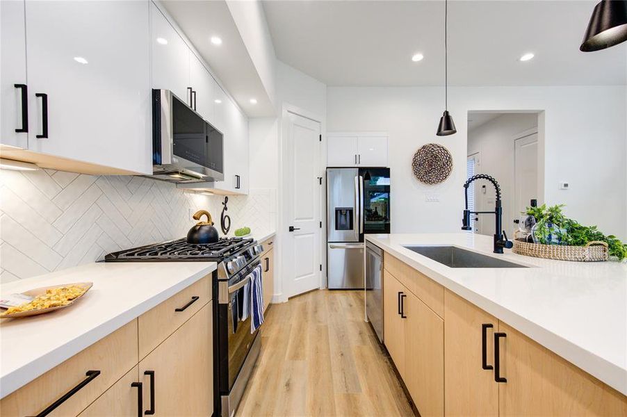 This luxurious kitchen comes with smart appliances, white quartz waterfall counters, modern European style soft-close cabinetry, walk-in pantry, and more! Fridge included!