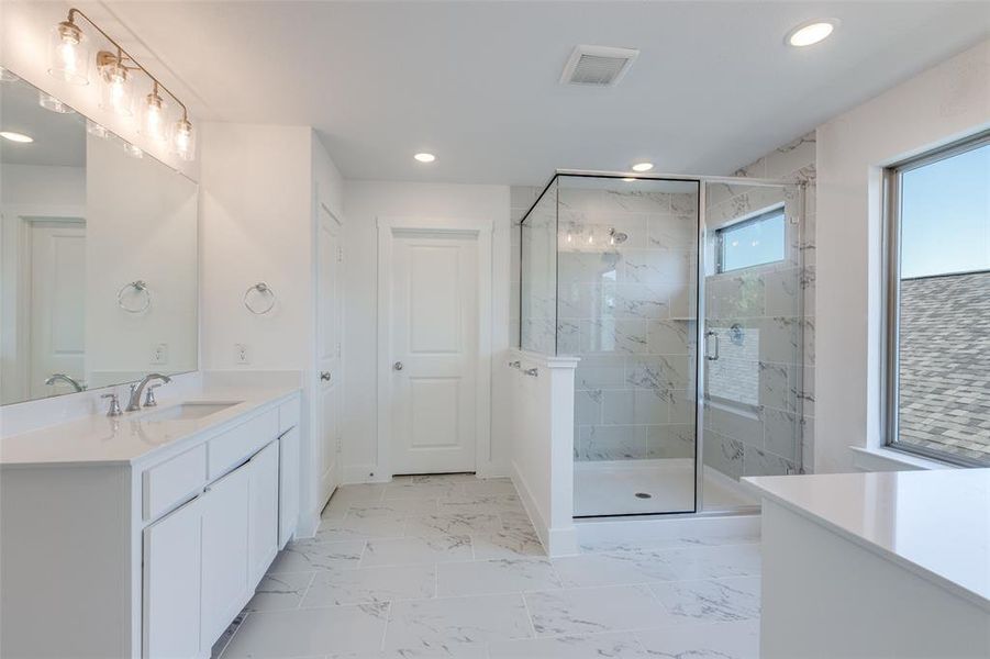 Bathroom featuring vanity and a shower with shower door