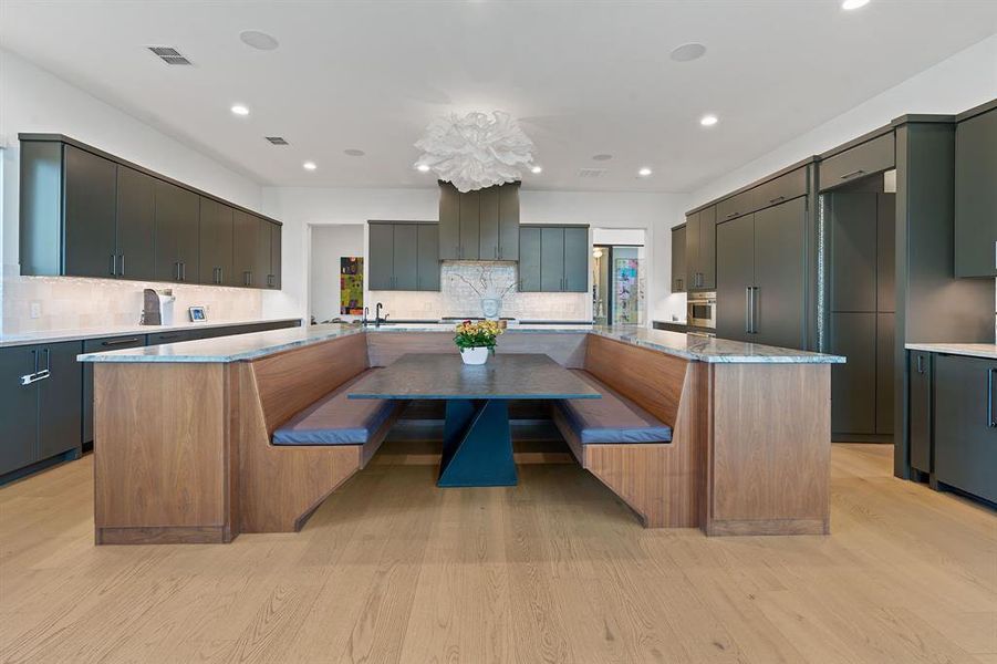 The designer gourmet chef's kitchen comes complete with an oversized restaurant-style built-in dining booth nestled in the U-shaped oversized center island.