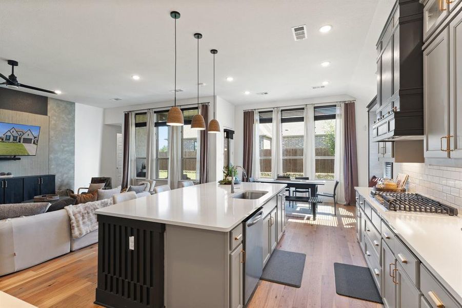 Kitchen featuring ceiling fan, an island with sink, wood-type flooring, sink, and appliances with stainless steel finishes