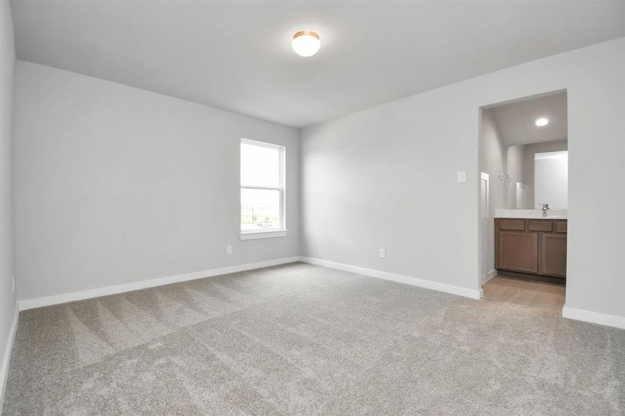 Secondary bedroom features plush carpet, custom paint, large window with privacy blinds and access to the Jack and Jill bath