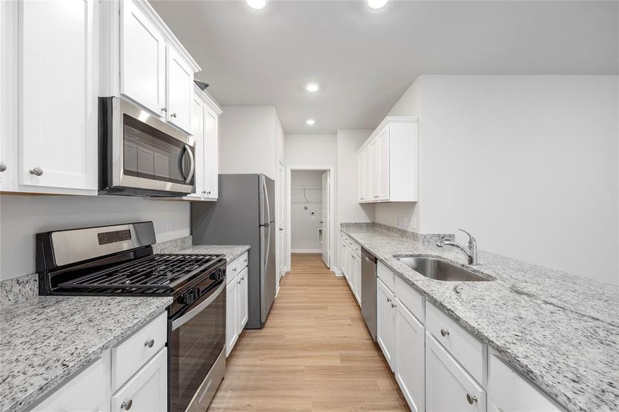 This chef-ready kitchen is stocked with stainless steel Whirlpool kitchen appliances and granite countertops.