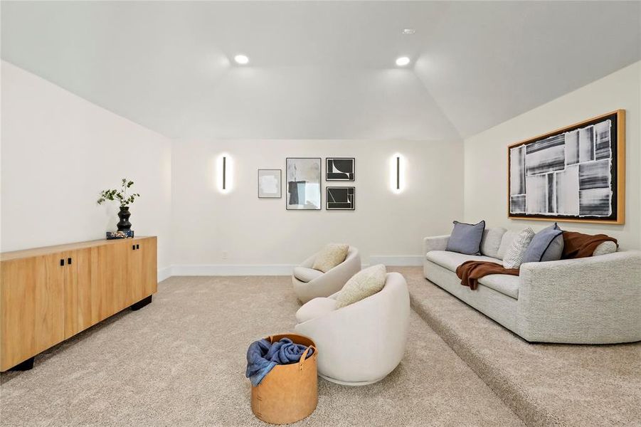 Living room with lofted ceiling and light colored carpet