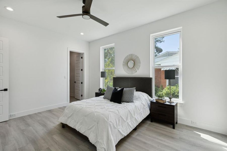 Bedroom featuring ceiling fan, light hardwood / wood-style flooring, and multiple windows