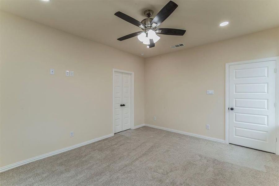 Carpeted spare room with ceiling fan