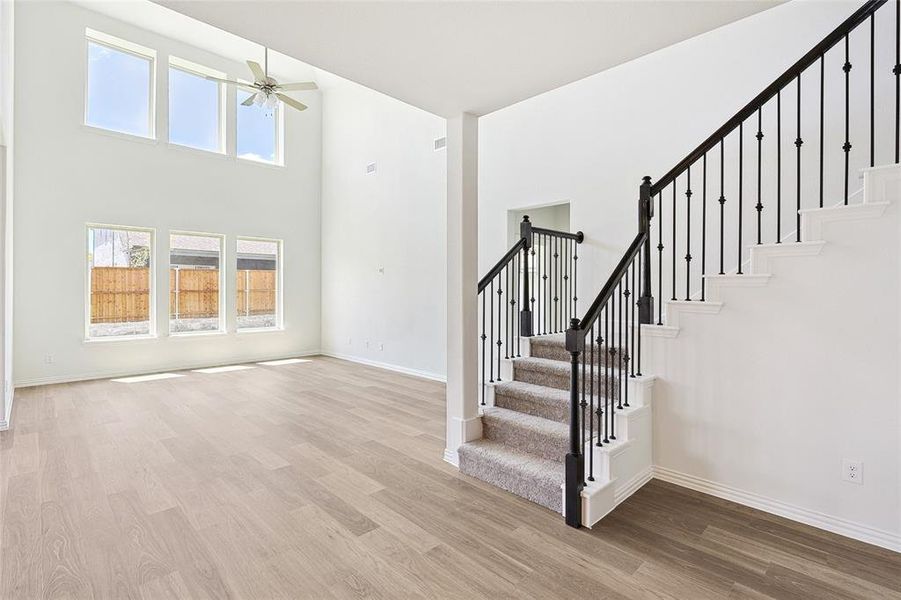 Stairway with hardwood / wood-style floors, a high ceiling, and ceiling fan