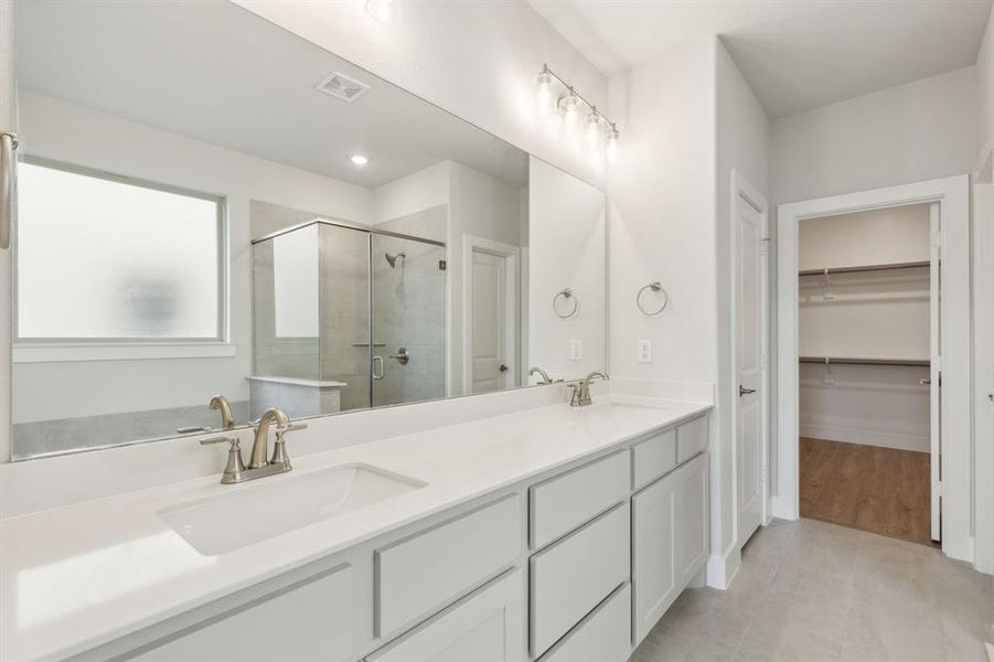 Bathroom with tile patterned floors, an enclosed shower, and vanity