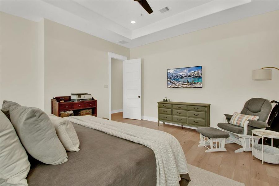 The spacious and well-lit bedroom features a beautiful tres-ceiling and neutral color palette with ample space for all sizes of furniture.