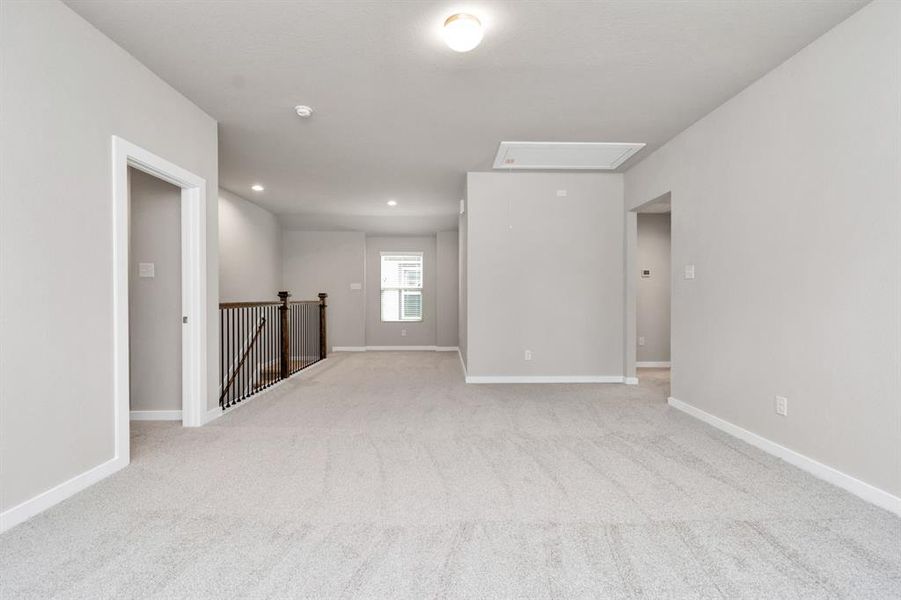 Come upstairs and enjoy a day of leisure in this fabulous game room! This is the perfect additional living area or adult game room! Features plush carpet, high ceilings, custom paint and windows for plenty of natural light. Sample photo of completed home with similar floor plan. As-built interior colors and selections may vary.