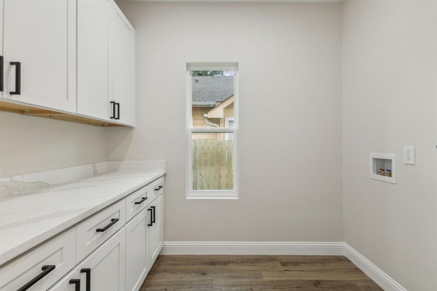 Laundry area featuring washer hookup, cabinets, and dark wood-type flooring