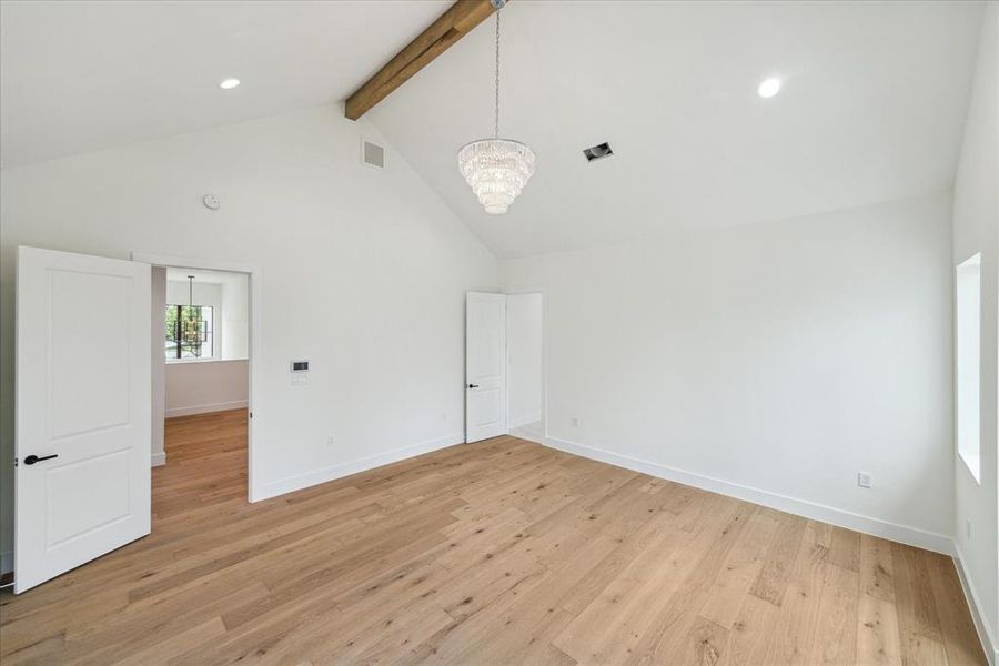 In the primary retreat, designer neutral wall paint and recessed LED lighting complement the vaulted ceiling with stained beam detail. The conveniently located laundry room is just across the hall, offering easy access and added functionality.