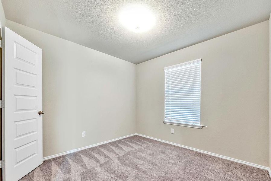 Carpeted empty room with a textured ceiling