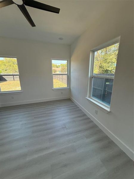 3rd bed room with ceiling fan and light Luxury Vinyl/wood-type flooring