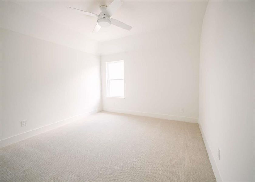 Carpeted spare room with ceiling fan