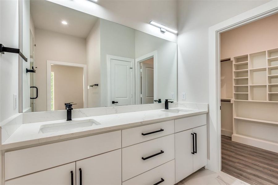 Bathroom with wood-type flooring and dual vanity