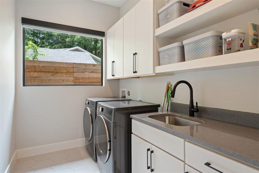 Large laundry room with built-in cabinetry, shelving and a sink