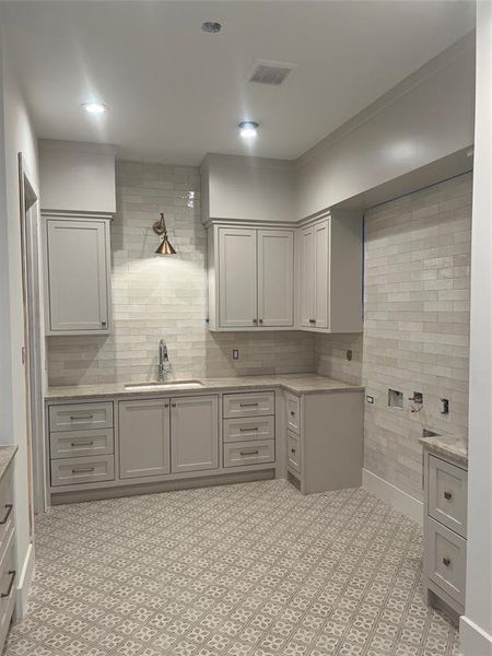 Laundry room with sink, craft desk and storage closet.