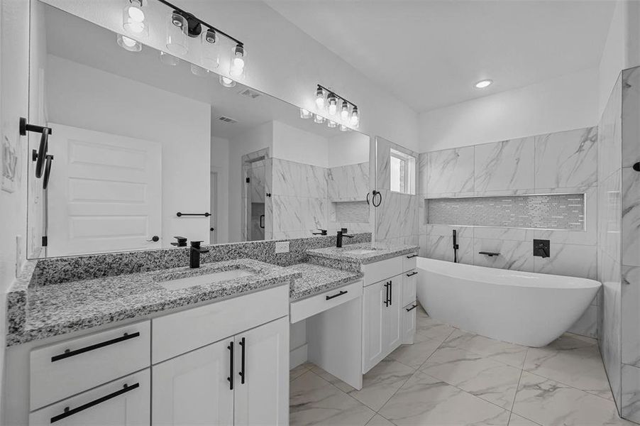Bathroom with tile walls, dual vanity, tile patterned floors, and a tub