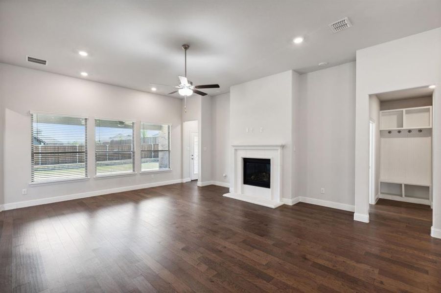 Unfurnished living room with dark hardwood / wood-style floors and ceiling fan