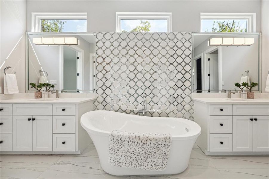 Primary Bathroom with elegant freestanding soaking tub and inlaid backsplash