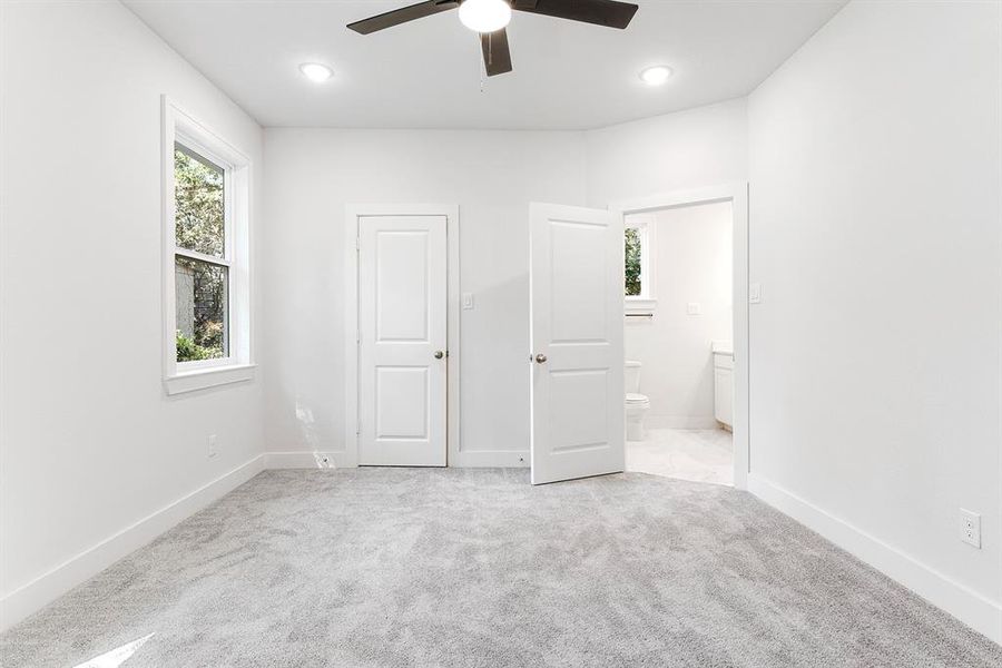 Primary bedroom with LED lighting.  One door is the other closet and then one leading to bathroom.