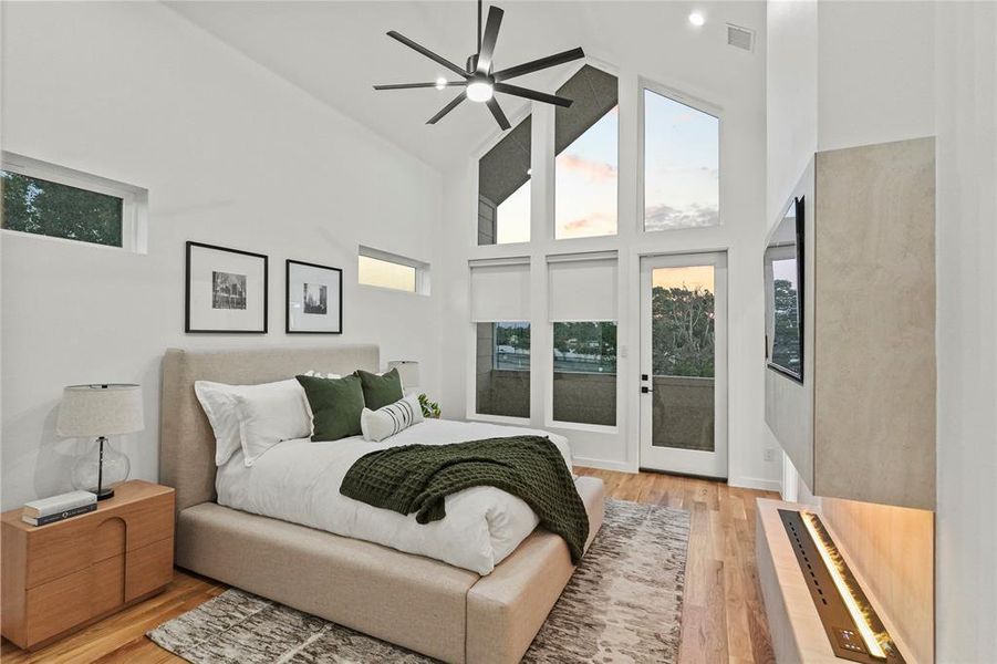 Bedroom with ceiling fan, light wood-type flooring, high vaulted ceiling, and access to outside