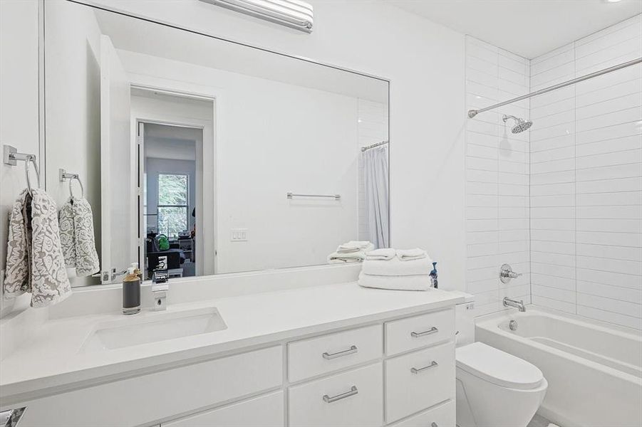 Full bathroom with toilet, vanity, and shower / tub combo