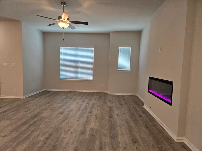 Unfurnished living room featuring ceiling fan and hardwood / wood-style flooring