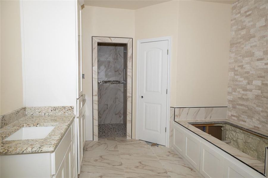 Bathroom featuring vanity, tile walls, and walk in shower