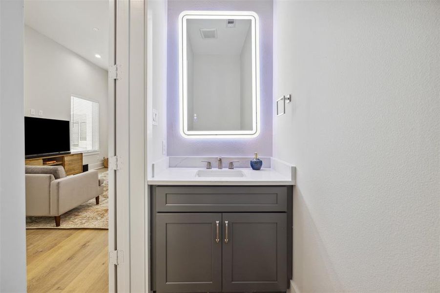 Powder room with quartz vanity is tucked away off the living area on the second floor.