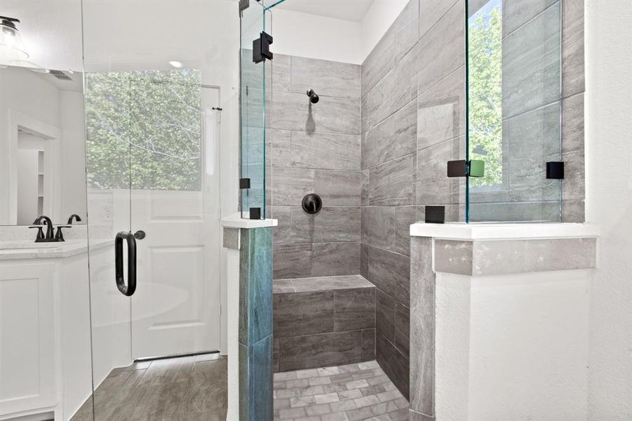 Bathroom with vanity, a shower with shower door, and hardwood / wood-style floors