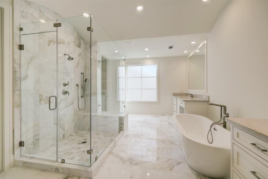 You will certainly feel refreshed in this elegant frameless glass shower with gorgeous marble tile to the ceiling! Shower head and separate wand plus a convenient bench will enhance the experience!!