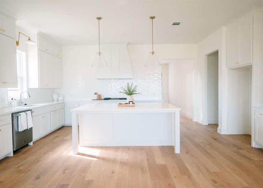 Kitchen with dishwasher, white cabinetry, and light hardwood / wood-style floors