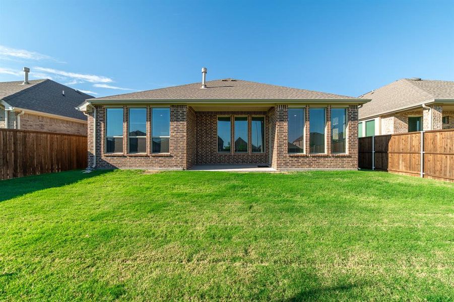 Back of house with a yard and a patio