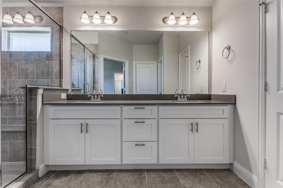 Bathroom featuring oversized vanity, dual sinks, and tile floors