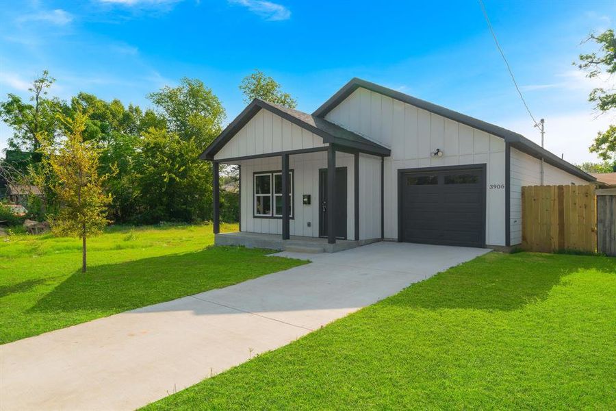 View of front facade featuring a front yard, a garage, and covered porch