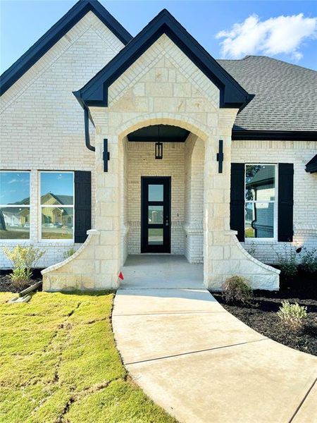 View of exterior entry with a lawn