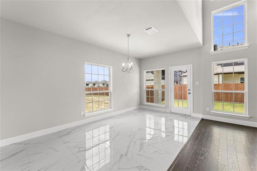 Unfurnished dining area featuring hardwood / wood-style flooring and a notable chandelier