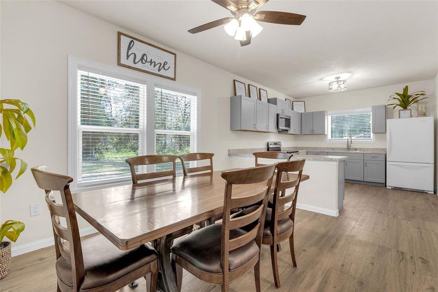 This is a bright, open-plan kitchen and dining area with ample natural light, and a cozy dining space, ideal for family meals and entertaining