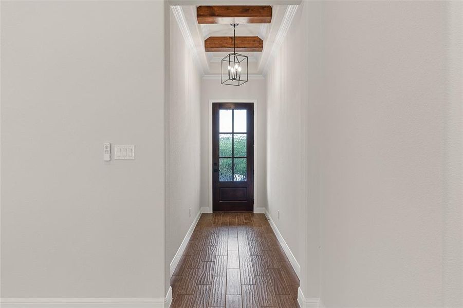 Entryway with an inviting chandelier, beamed ceiling, and dark hardwood / wood-style floors
