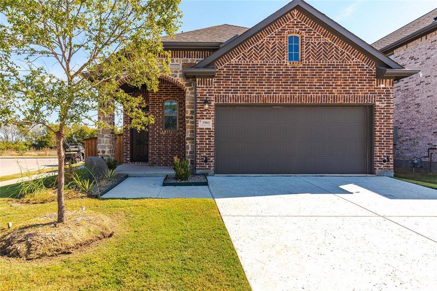 View of property featuring a front yard and a garage