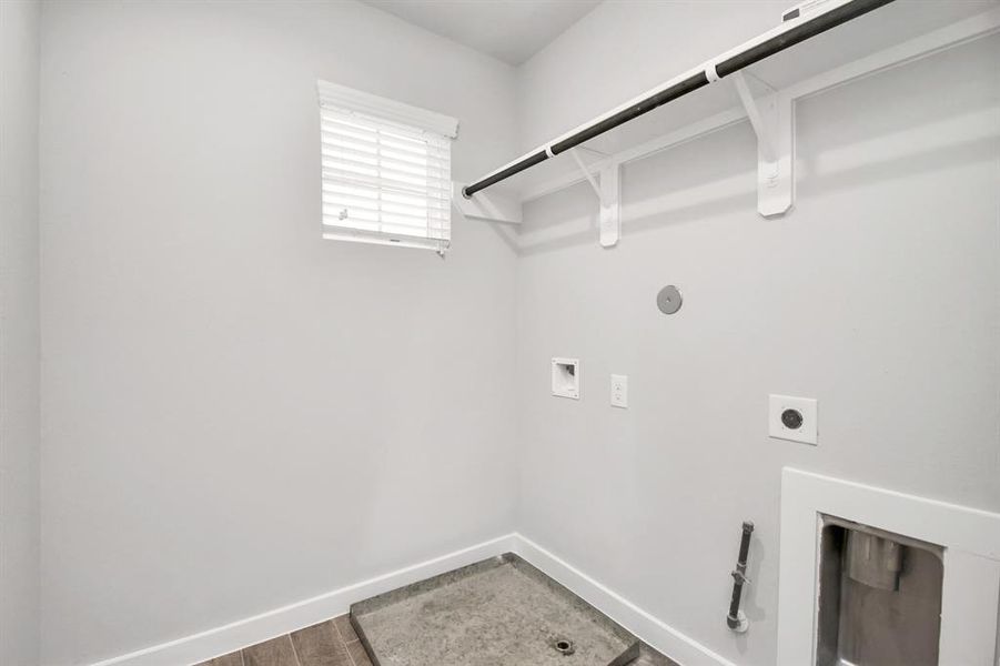 Located on the 2nd floor, a stylish laundry room where practicality meets a contemporary aesthetic. The dark finishes lend a sophisticated touch, creating a space that is both functional and visually appealing. Both electric and gas connections available. Sample photo of completed home with similar floor plan. As-built interior colors and selections may vary.