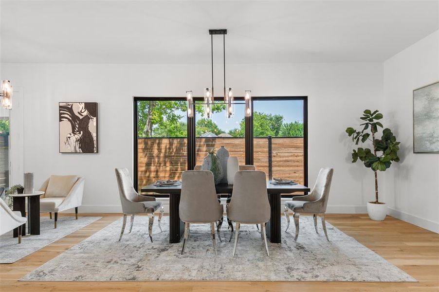 Dining room with light wood-type flooring, a chandelier, and plenty of natural light