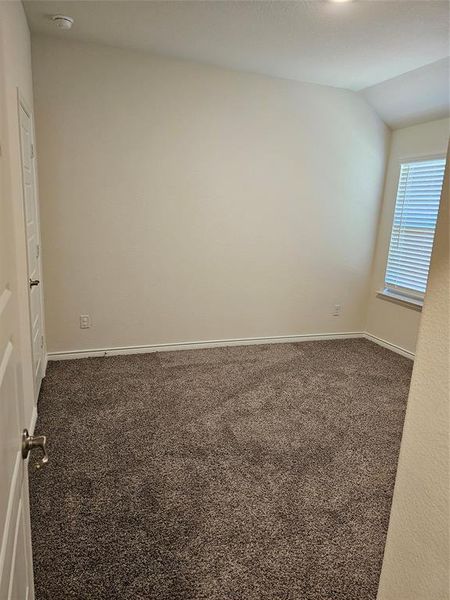 Carpeted empty room with lofted ceiling