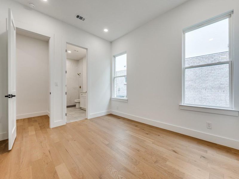 Unfurnished bedroom with light wood-type flooring and ensuite bathroom