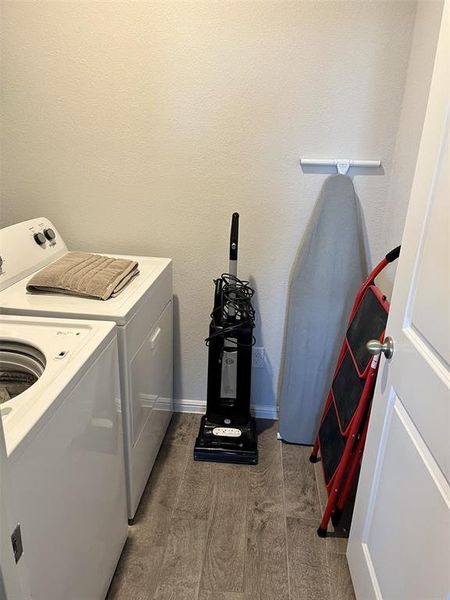 Clothes washing area with separate washer and dryer and dark hardwood / wood-style flooring