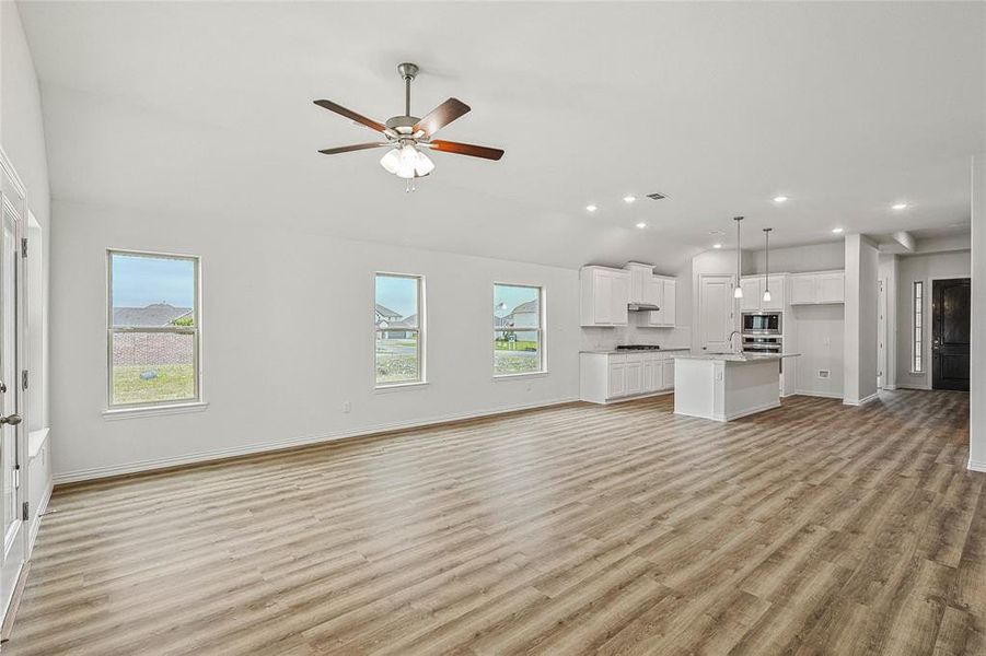 Unfurnished living room with sink, light wood-type flooring, and ceiling fan