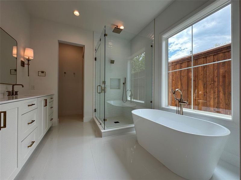 Bathroom featuring shower with separate bathtub, tile patterned floors, and vanity