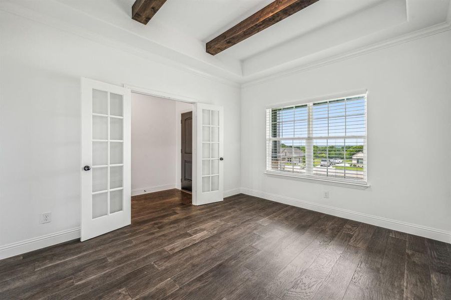 Spare room with beamed ceiling, french doors, crown molding, and hardwood / wood-style floors